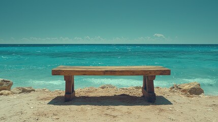 Fototapeta premium Wooden bench on a sandy beach overlooking the turquoise ocean under a clear blue sky, symbolizing relaxation, solitude, and natural beauty in a tranquil coastal setting.