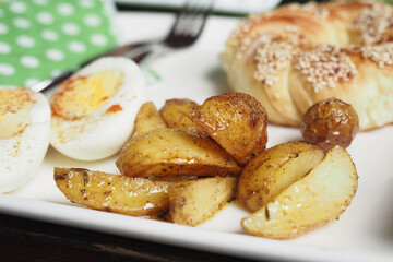 An incredibly delicious breakfast plate featuring eggs, potatoes, and pastry