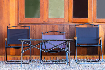 Beautiful chairs are placed in front of the house in a beautiful corner amidst the flower garden.