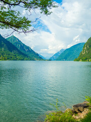 Serene Lake Idro Surrounded by Majestic Mountains and Cloudy sky, Italy, Crone