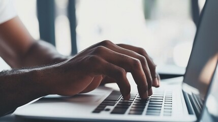 Fototapeta premium Focused Hands Typing on Laptop Keyboard in Bright Indoor Space