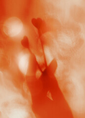 Blurred shadow of hand with two hearts. Light flares and shadow.  Atmospheric mood and wellbeing....