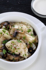 Dumplings with potatoes and mushrooms on a black background