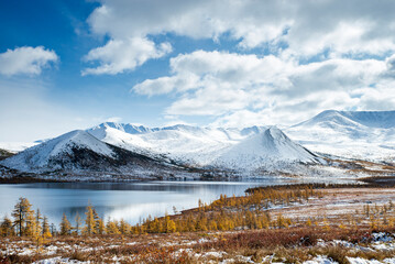 Russia. Magadan Region. Beautiful Lake Momontay against the backdrop of a snowy mountain range. Late autumn in the vicinity of Lake Momontay.