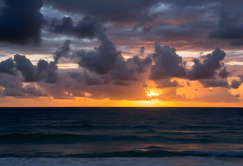 Obraz premium Dramatic sunset over ocean, Vibrant orange and gold sky, Dark stormy clouds, Calm sea reflections, Moody seascape, Twilight horizon, Atmospheric cloudscape, Serene coastal scene, Rich color palette, 