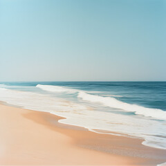 Obraz premium Seascape Serenity: A calming panorama of a tranquil beach, showcasing a gentle wave rolling onto the shore against a backdrop of a clear blue sky. The image exudes a sense of serenity and peace.