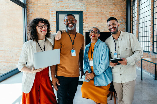 Diverse group of professionals smiling in a modern office setting - Powered by Adobe