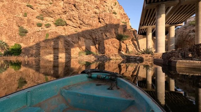 A boat sails down a river in Oman on a calm morning. Wadi Shab in Oman. Wad Shab is iconic tourist spot in Oman