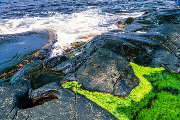 Seashore on a rocky coast with Glacial pothole in the rock by the sea