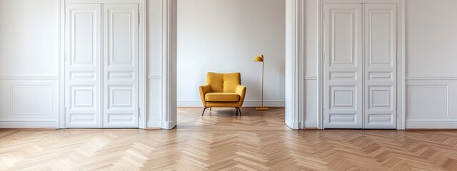Yellow armchair in minimalist room with herringbone floors and white doors.