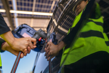 Engineer in safety vest and helmet pointing towards a solar powered carport, illustrating eco-friendly innovation in parking infrastructure. Solar panels provide shade and sustainable energy.