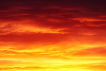Obraz premium A vibrant sunset casts a fiery gradient across the sky, blending rich orange and deep red colors. This captivating display creates a breathtaking view as evening approaches, enhancing the landscape