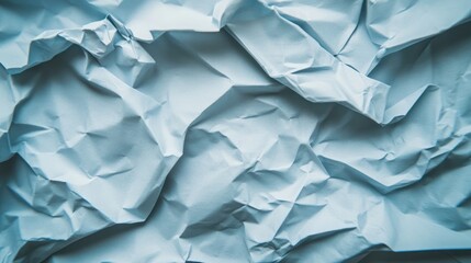 Obraz premium Crumpled light blue paper texture with natural creases and folds.