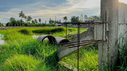 Abandoned industrial site with overgrown grass and pipes rural area landscape photography natural...