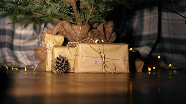 Gift wrapped in brown paper and string with Christmas lights bokeh background