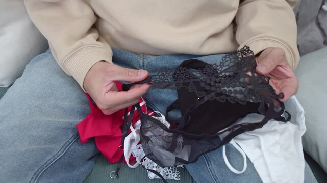 A Person is Holding a Selection of Lingerie - Close Up