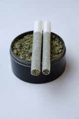 Macro of marijuana joints with crushed weed in a grinder for chopping. Isolate