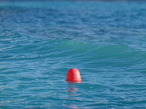 Wave crest and stationary red buoy out at sea, Monaco