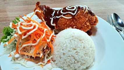 A plate of chicken cordon bleu, rice, and carrot salad for lunch