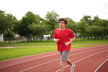 Fototapeta premium Man jogging along a running track alone