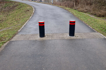 Retractable automatic bollards and other parking bollards serve to reliably secure public spaces and effectively prevent entry into pedestrian zones or other areas with limited motor vehicle access