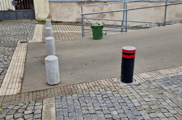 Retractable automatic bollards and other parking bollards serve to reliably secure public spaces and effectively prevent entry into pedestrian zones or other areas with limited motor vehicle access