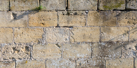 background large bricks wall of yellow square rock texture of the old building facade