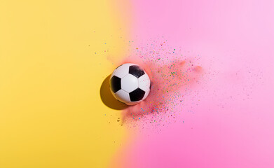 Soccer ball rolling across a vibrant background with colorful powder explosion in a playful atmosphere