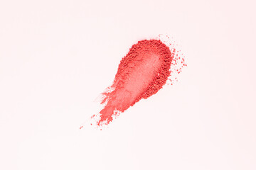 A beautiful sample texture of loose pink blush. Brushstroke on a white background. The texture of a cosmetic dry product. top view. A copy space.