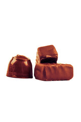 chocolate with filling inside. there are three of them. one candy is round. close-up. there are three of them.