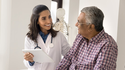 Tech innovations in medicine. Smiling female doctor use digital tablet on consultation show lab...