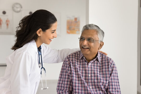 Your health is in caring professional hands. Smiling female medic worker hug shoulder of happy senior male patient support at medical appointment encourage before surgery help struggle with diagnosis