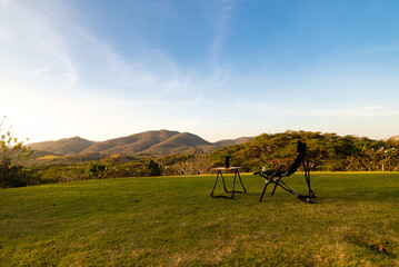 Camping under the pine forest in sunset,
Red sunset and mountains in the background, Summer landscape.