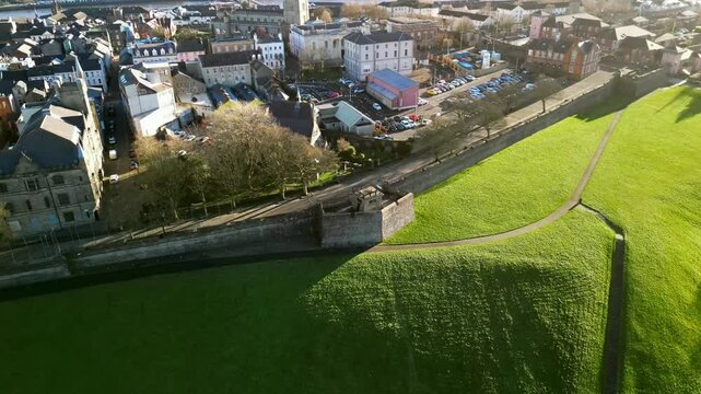 Wide aerial of The Derry Walls in Derry-Londonderry, Northern Ireland on a bright sunny day. The camera pulls away from the walls to reveal the city. Filmed in 4K at 30fps with Rec709 color.