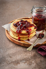 Pancakes, fluffy, breakfast, brunch, berry, jam, syrup, sweet, rustic, food, homemade, cozy, delicious, comfort, healthy. Fluffy pancakes with berry jam on a rustic board.
