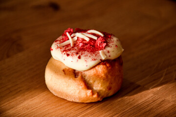 Sweet pink donut with sprinkles and strawberry topping