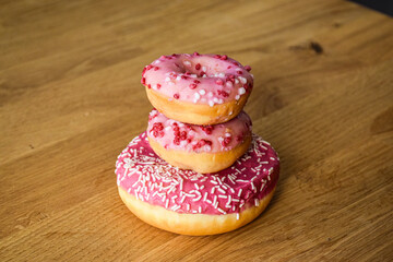 Sweet pink donut with sprinkles and strawberry topping