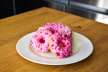 Sweet pink donut with sprinkles and strawberry topping