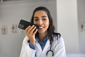 Artificial intelligence in medicare. Young female doctor family therapist command to ai assistant...