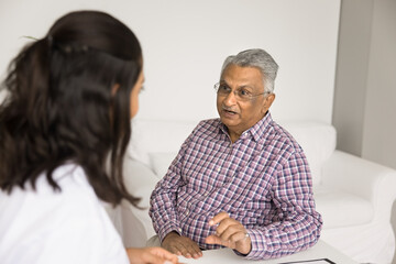 Healthcare appointment. Serious old age male patient visit attending physician sit at doctor desk...