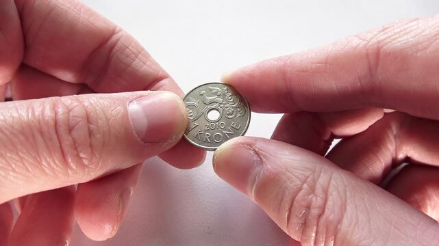 Norwegian Krone Coin in Hands. Macro Detail of Currency. 1 CRONE NORGE 2010 year.
