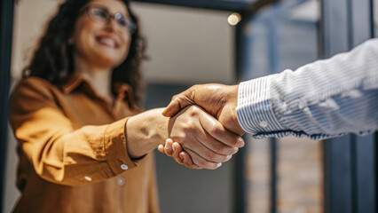Handshake between hiring manager and candidate in office setting, conveying professionalism and opportunity