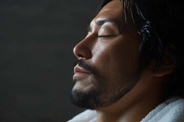 Obraz premium Relaxed Asian man with glowing skin and towel, enjoying self-care, ideal for skincare, grooming, spa, relaxation, and wellness concepts