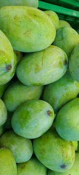 close up of A pile of fresh green mangoes, on display at a fruit shop