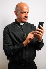 Portrait of a priest holding a smartphone.