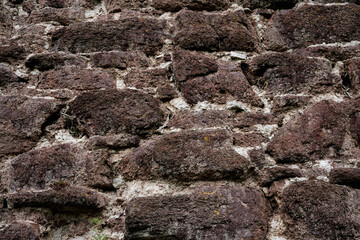 A wall made of stone with a rough texture. The wall is brown and white