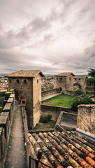 Obraz premium Medieval stone towers and walkway in a fortified city of Carcassonne fortress under a cloudy sky overlooking the city.