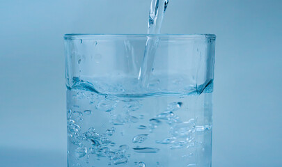 Clear water streams into a glass