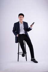 Full body Young business man wearing a vest using phone and posing on a blue background