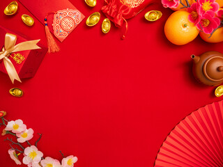 flat lay of lucky item decoration ornament for Chinese Lunar New Year celebration red background with ancient Chinese gold bar, gift box , paper hand fan, Tae Eia envelope (red envelope), orange, plum